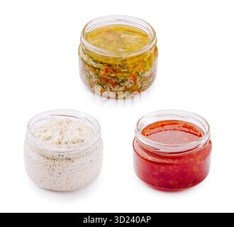 Assortimento di tre salse fatte in casa in vasetti di vetro su sfondo bianco Foto Stock
