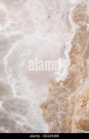 Onde che si infrangono su una costa rocciosa al crepuscolo creando un'atmosfera nebbiosa e rilassante Foto Stock