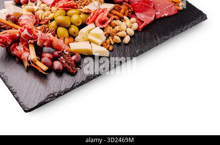 Tagliere di salumi e formaggi assortiti su un tagliere di ardesia con noci e olive Foto Stock