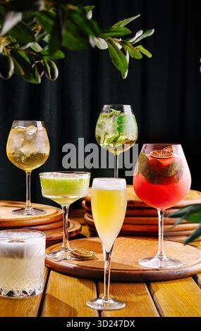 Cocktail colorati serviti su superfici in legno in un elegante ambiente bar Foto Stock