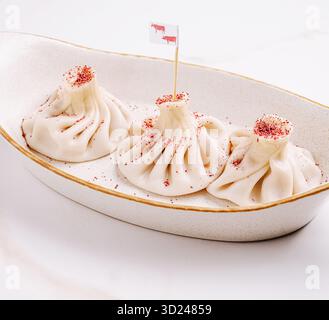 Deliziosi gnocchi fatti a mano serviti con una bandiera decorativa in una ciotola Foto Stock