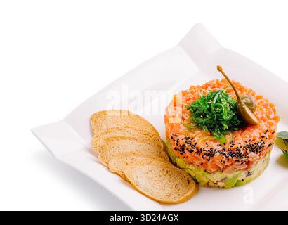 Tartare di salmone fresco servito con pane croccante e un contorno di erbe aromatiche Foto Stock