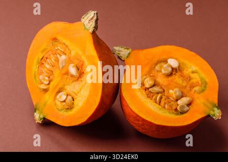 Mezza zucca cruda, una zucca di color arancio matura. Zucca cruda Foto Stock