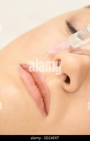 Donna che riceve un'iniezione cosmetica in vista ravvicinata della guancia Foto Stock