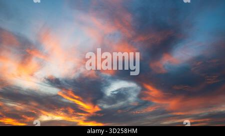 Cielo spettacolare e vibrante al tramonto e nuvole in una soleggiata serata estiva. Vista grandangolare, niente persone Foto Stock