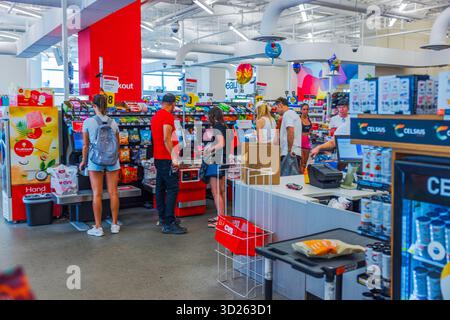 Persone in fila presso l'area di check-out self-service del punto vendita CVC con prodotti e spuntini sugli scaffali sullo sfondo. Miami Beach. STATI UNITI. Foto Stock
