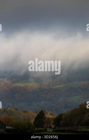 I colori autunnali sulla collina Pennine sopra Todmorden, West Yorkshire, come la nebbia di prima mattina avvolge i lontani mulini a vento e le turbine dando alle colline e alle brughiere un aspetto quasi dipinto. Foto Stock