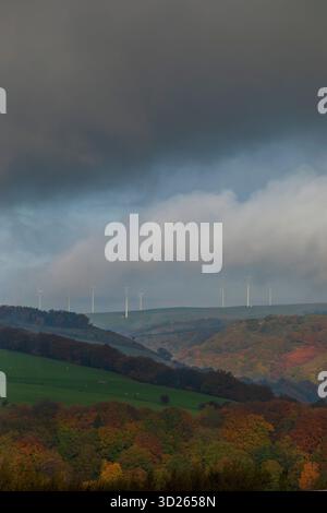I colori autunnali sulla collina Pennine sopra Todmorden, West Yorkshire, come la nebbia di prima mattina avvolge i lontani mulini a vento e le turbine dando alle colline e alle brughiere un aspetto quasi dipinto. Foto Stock