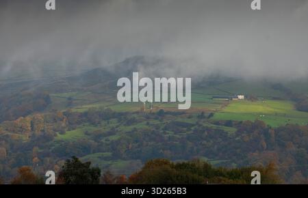 I colori autunnali sulla collina Pennine sopra Todmorden, West Yorkshire, come la nebbia di prima mattina avvolge i lontani mulini a vento e le turbine dando alle colline e alle brughiere un aspetto quasi dipinto. Foto Stock