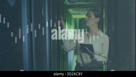 Tenere premuto il tecnico sul server rack nella sala server con tablet e grafici dati, copiare spazio Foto Stock