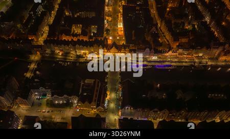 La vista aerea notturna della città vecchia di Danzica in Polonia mostra il fiume Motlawa, la gru Zuraw, il mercato lungo e la porta Verde, le barche blu illuminate e il caldo amb Foto Stock