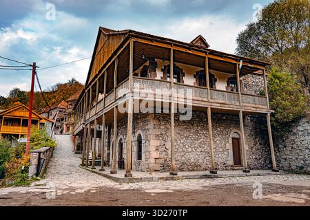 Un grande vecchio edificio in pietra con un balcone e un piccolo cortile. L'edificio e' vecchio e ha un'atmosfera rustica Foto Stock