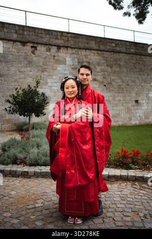 Coppie multiculturali che celebrano il giorno del matrimonio in un abbigliamento tradizionale cinese Foto Stock