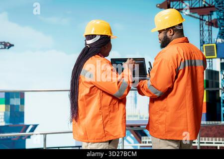 Team di progettazione su piattaforma offshore che utilizza un ampio modello linguistico ai per migliorare la precisione della perforazione. I colleghi di lavoro di squadra utilizzano un modello di intelligenza artificiale predittiva per prevenire i malfunzionamenti Foto Stock