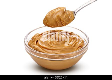 Una ciotola piena di crema di burro di arachidi e un cucchiaio che riposa accanto, pronti per il divertimento Foto Stock