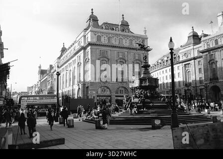Regent Street, Londra - Una scena senza tempo si svolge su Regent Street, dove la grandezza dell'ex Lione Tea Building si erge in netto contrasto con la folla animata sottostante. L'iconica fontana, un punto focale della strada, riflette la vibrante energia di questa storica strada londinese. Sia gli amanti dello shopping che i turisti si riuniscono intorno alla fontana, catturando un momento nel cuore di una delle più prestigiose destinazioni per lo shopping di Londra. Foto Stock