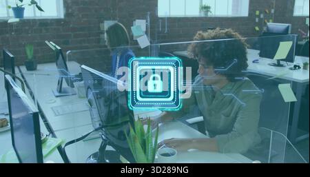 Digitare un uomo dai capelli ricci che utilizza un laptop in un ufficio open space, mostrare la sovrapposizione del blocco di sicurezza e lo spazio per le copie Foto Stock