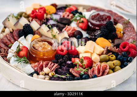 Primo piano di salumi colorati con carni, formaggi e frutta. Foto Stock