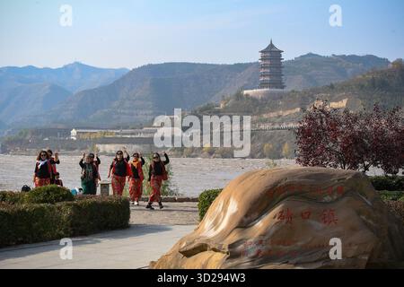(251031) -- TAIYUAN, 31 ottobre 2025 (Xinhua) -- i turisti ballano nell'antica città di Qikou della contea di Linxian, nella provincia dello Shanxi della Cina settentrionale il 30 ottobre 2025. Qikou, un'antica città lungo il fiume giallo, era un importante traghetto commerciale nella storia, dove i mercanti scaricavano merci come pellicce, lana ed erbe dalle barche che arrivavano a monte e passavano al trasporto terrestre per consegnarle ulteriormente a città come Taiyuan, Pechino e Tianjin. Un tale vantaggio geografico rese Qikou un porto importante fino agli anni '1970 Tuttavia, la gloria di Qikou gradualmente svanì nei decenni successivi come trasporto terrestre ne Foto Stock