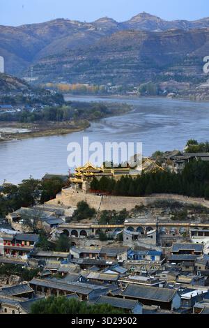 (251031) -- TAIYUAN, 31 ottobre 2025 (Xinhua) -- una foto aerea del drone scattata il 29 ottobre 2025 mostra una vista dell'antica città di Qikou nella contea di Linxian, nella provincia dello Shanxi della Cina settentrionale. Qikou, un'antica città lungo il fiume giallo, era un importante traghetto commerciale nella storia, dove i mercanti scaricavano merci come pellicce, lana ed erbe dalle barche che arrivavano a monte e passavano al trasporto terrestre per consegnarle ulteriormente a città come Taiyuan, Pechino e Tianjin. Un tale vantaggio geografico rese Qikou un porto importante fino agli anni '1970 Tuttavia, la gloria di Qikou svanì gradualmente nei decenni successivi Foto Stock