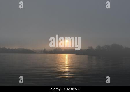 Il sole sorge attraverso la nebbia e le nuvole in una fresca mattina di novembre sull'isola di Harakka, Helsinki, Finlandia. Questa è una delle albe più drammatiche che abbia mai visto Foto Stock