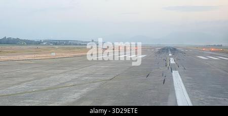 Doloman, Turchia - 25 aprile 2025: Veduta della pista dell'aeroporto con luci che illuminano la superficie e le montagne circostanti. Foto Stock