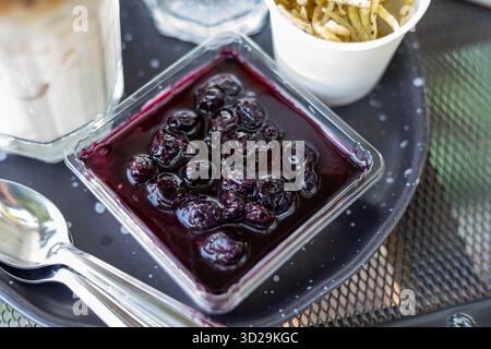 Vista dall'alto della Burberry Cheesecake in una tazza di plastica in una caffetteria. Questo appetitoso dessert è molto delizioso e ti farà diventare molto grasso. Foto Stock