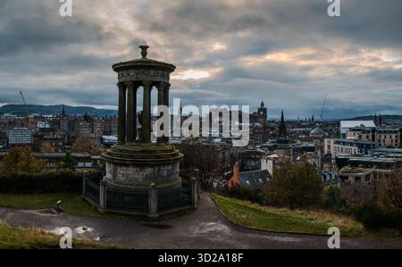 Vista serale in tarda autunno da Calton Hill che si affaccia su Edimburgo, con la città immersa nelle tenui tonalità del tramonto sotto nuvole ricoperte Foto Stock