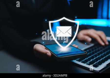 Concetto di sicurezza e-mail. L'icona dello scudo e il simbolo della busta sullo schermo dello smartphone rappresentano la protezione dei dati, la privacy, la sicurezza informatica, i comuni digitali sicuri Foto Stock