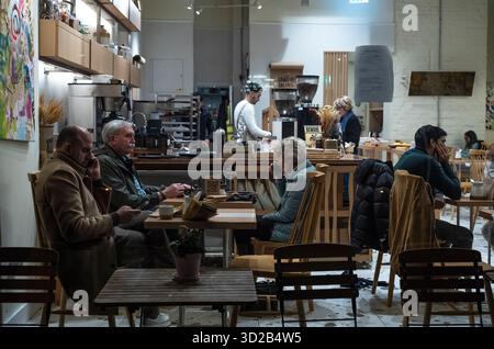 Le persone si siedono all'interno di un affollato caffè situato lungo Piccadilly, nel cuore di Mayfair, Londra, Inghilterra, Regno Unito Foto Stock