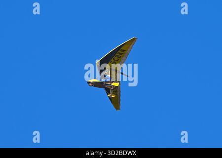 Un aereo a microluce giallo G-CBKN in volo contro un cielo blu. REGNO UNITO Foto Stock
