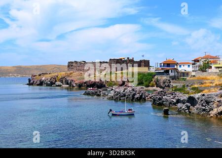 Paesaggio panoramico con antico forte ottomano e barca da pesca nel villaggio costiero di Sigri sull'isola di Lesbo, in Grecia. Foto Stock