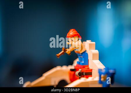 Primo piano del pirata LEGO su una nave bianca e rossa con pistola, scena al chiuso Foto Stock