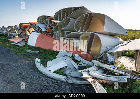 Windenergie - zerteilte Rotorenblätter eines Windrades warten auf ihren Abtransport zum Recycling. Entsorgung Alter Windrad-Rotoren im Rahmen einer repowering Maßnahme eines vorhandenen Windparks. Bevor neue, leistungsstärkere Winkraftanlage installiert werden können, müssen zunächst die Altanlagen weichen. Inder Praxis werden die Türme meist gesprengt , Die als Verbundstoffen bestehenden Rotoren werden in kleinere Stücke zerlegt und entsorgt. Es soll entsprechende Recycling-Verfahren zur Weiterverwendung der Materialien geben. Regione Weser-EMS Niedersachsen Deutschland *** energia eolica Dismant Foto Stock