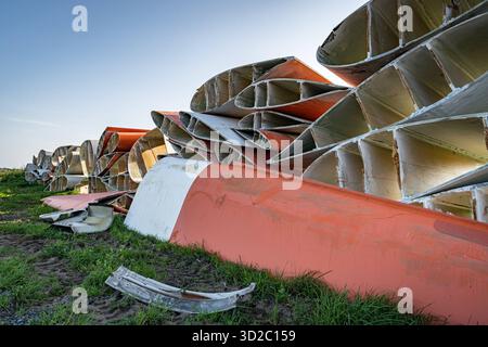 Windenergie - zerteilte Rotorenblätter eines Windrades warten auf ihren Abtransport zum Recycling. Entsorgung Alter Windrad-Rotoren im Rahmen einer repowering Maßnahme eines vorhandenen Windparks. Bevor neue, leistungsstärkere Winkraftanlage installiert werden können, müssen zunächst die Altanlagen weichen. Inder Praxis werden die Türme meist gesprengt , Die als Verbundstoffen bestehenden Rotoren werden in kleinere Stücke zerlegt und entsorgt. Es soll entsprechende Recycling-Verfahren zur Weiterverwendung der Materialien geben. Regione Weser-EMS Niedersachsen Deutschland *** energia eolica Dismant Foto Stock