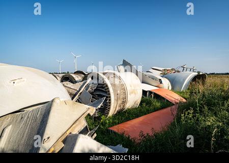 Windenergie - zerteilte Rotorenblätter eines Windrades warten auf ihren Abtransport zum Recycling. Entsorgung Alter Windrad-Rotoren im Rahmen einer repowering Maßnahme eines vorhandenen Windparks. Bevor neue, leistungsstärkere Winkraftanlage installiert werden können, müssen zunächst die Altanlagen weichen. Inder Praxis werden die Türme meist gesprengt , Die als Verbundstoffen bestehenden Rotoren werden in kleinere Stücke zerlegt und entsorgt. Es soll entsprechende Recycling-Verfahren zur Weiterverwendung der Materialien geben. Regione Weser-EMS Niedersachsen Deutschland *** energia eolica Dismant Foto Stock