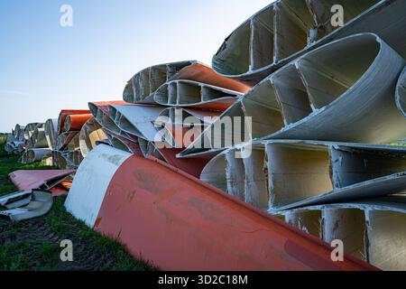 Windenergie - zerteilte Rotorenblätter eines Windrades warten auf ihren Abtransport zum Recycling. Entsorgung Alter Windrad-Rotoren im Rahmen einer repowering Maßnahme eines vorhandenen Windparks. Bevor neue, leistungsstärkere Winkraftanlage installiert werden können, müssen zunächst die Altanlagen weichen. Inder Praxis werden die Türme meist gesprengt , Die als Verbundstoffen bestehenden Rotoren werden in kleinere Stücke zerlegt und entsorgt. Es soll entsprechende Recycling-Verfahren zur Weiterverwendung der Materialien geben. Regione Weser-EMS Niedersachsen Deutschland *** energia eolica Dismant Foto Stock