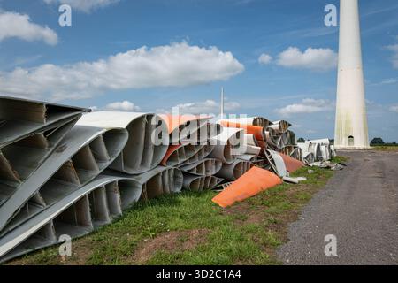 Windenergie - zerteilte Rotorenblätter eines Windrades warten auf ihren Abtransport zum Recycling. Entsorgung Alter Windrad-Rotoren im Rahmen einer repowering Maßnahme eines vorhandenen Windparks. Bevor neue, leistungsstärkere Winkraftanlage installiert werden können, müssen zunächst die Altanlagen weichen. Inder Praxis werden die Türme meist gesprengt , Die als Verbundstoffen bestehenden Rotoren werden in kleinere Stücke zerlegt und entsorgt. Es soll entsprechende Recycling-Verfahren zur Weiterverwendung der Materialien geben. Regione Weser-EMS Niedersachsen Deutschland *** energia eolica Dismant Foto Stock