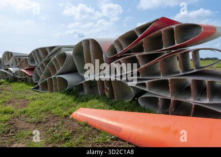 Windenergie - zerteilte Rotorenblätter eines Windrades warten auf ihren Abtransport zum Recycling. Entsorgung Alter Windrad-Rotoren im Rahmen einer repowering Maßnahme eines vorhandenen Windparks. Bevor neue, leistungsstärkere Winkraftanlage installiert werden können, müssen zunächst die Altanlagen weichen. Inder Praxis werden die Türme meist gesprengt , Die als Verbundstoffen bestehenden Rotoren werden in kleinere Stücke zerlegt und entsorgt. Es soll entsprechende Recycling-Verfahren zur Weiterverwendung der Materialien geben. Regione Weser-EMS Niedersachsen Deutschland *** energia eolica Dismant Foto Stock