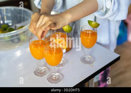 Fette di mandarino focalizzate selettive sul labbro di un bicchiere di succo d'arancia appena spremuto succo di frutta fresco bevande dal frutteto d'arancia per assaggiare oran Foto Stock