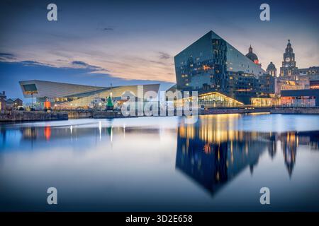 Vista del tramonto del Royal Albert Dock a Liverpool, Inghilterra, con il Museo di Liverpool, la Galleria Open Eye e la Royal Liver Suite illuminata da Foto Stock