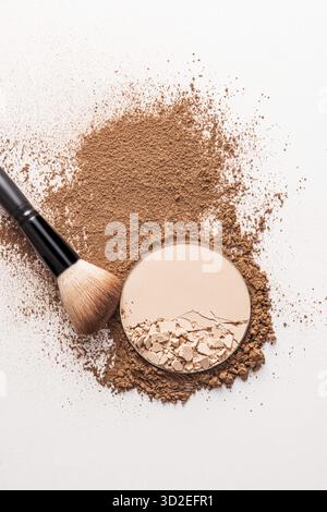 Sfondo cosmetico per presentazione, texture o pubblicità di prodotti. con polvere compatta a blocchi, polvere sfuso, spazzola per il trucco soffice. vista dall'alto verticale Foto Stock