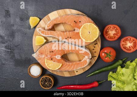 Due grandi bistecche di salmone crudo su una tavola rotonda di legno per cucinare piatti deliziosi. ingredienti per migliorare il gusto. vista dall'alto Foto Stock