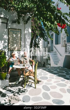 Una coppia siede al Café Symposium nella città vecchia di Parikia, Paros, Grecia Foto Stock