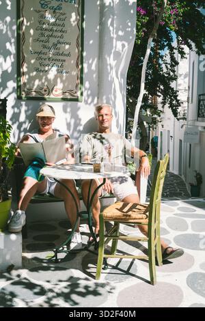 Una coppia siede al Café Symposium nella città vecchia di Parikia, Paros, Grecia Foto Stock