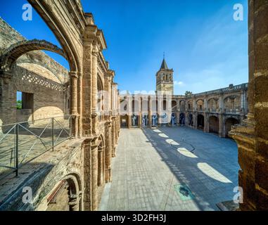 Esplora la bellezza architettonica rinascimentale del chiostro del monastero di San Jeronimo a Siviglia, con colonnati ad arco e un cortile luminoso. Foto Stock