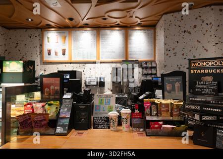 Hong Kong, Cina - 20 settembre 2025: L'area del banco di servizio all'interno della caffetteria Starbucks presso l'Aeroporto Internazionale di Hong Kong (HKIA). Foto Stock