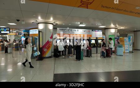 SEOUL, COREA DEL SUD - 11 OTTOBRE 2025 - viaggiatori che acquistano biglietti ferroviari espressi da macchine automatiche presso l'aeroporto internazionale di Incheon Foto Stock