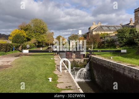 Il canale Kennet e Avon, le sue porte chiuse e il suo sentiero in un giorno di sole ottobre, città di Bath, Somerset, Inghilterra, Regno Unito Foto Stock