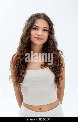 Donna sicura di sé in studio con trucco naturale e atteggiamento amichevole, Ritratto di donna sorridente che presenta eleganza informale con caratteristiche naturali e. Foto Stock